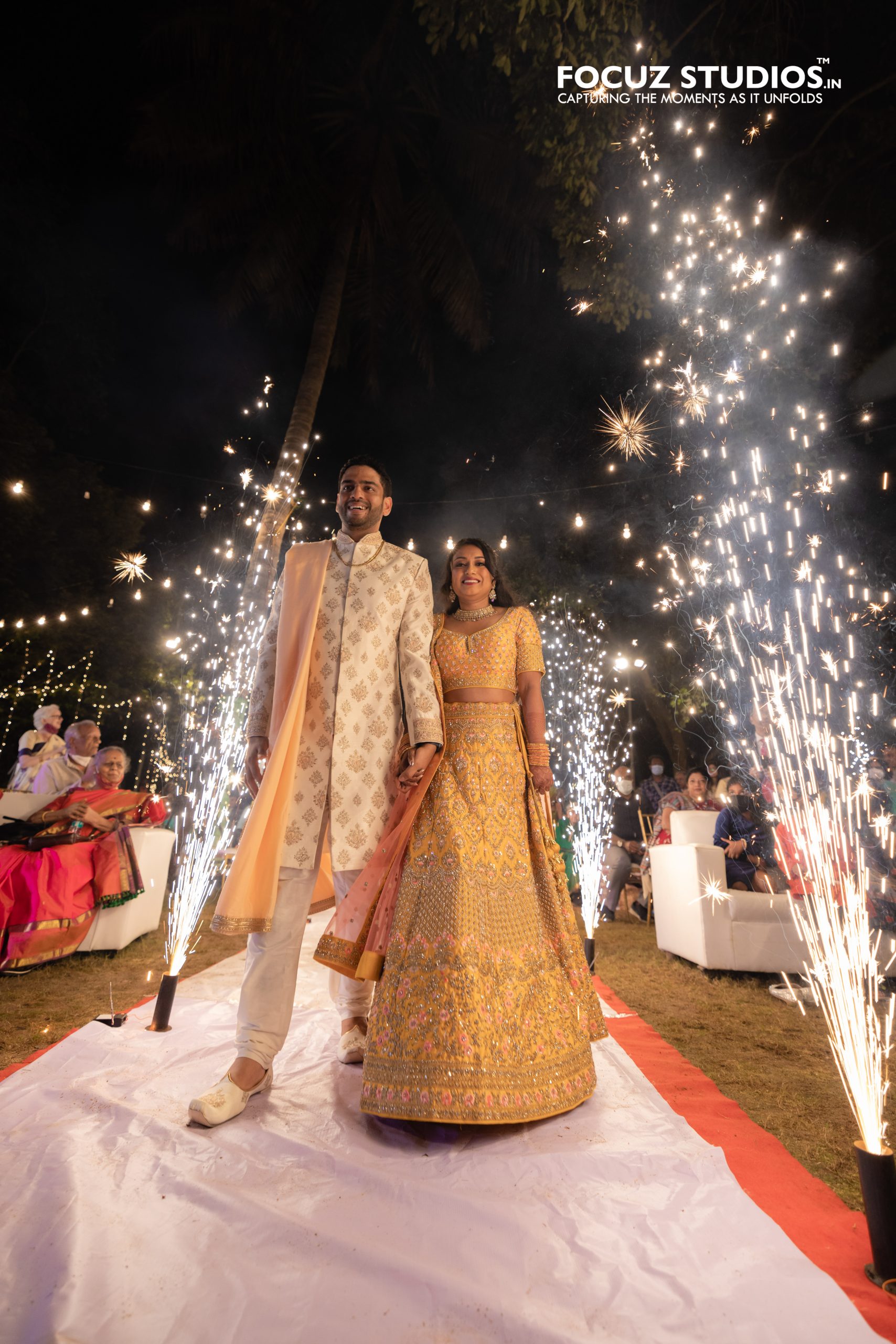 Nikita and Pranav walking through sparkler Sangeet entrance